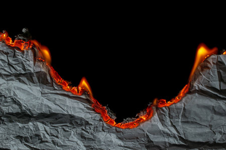 burning paper, glowing edge of paper on a black backgroundの写真素材