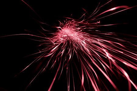 red sparks from the grinder glowing in the dark straight aheadの写真素材