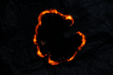 burning paper, glowing edge of paper on a black backgroundの写真素材