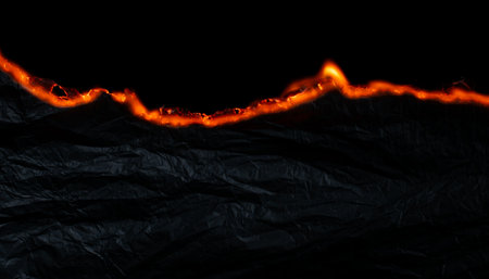 burning paper, glowing edge of paper on a black backgroundの写真素材
