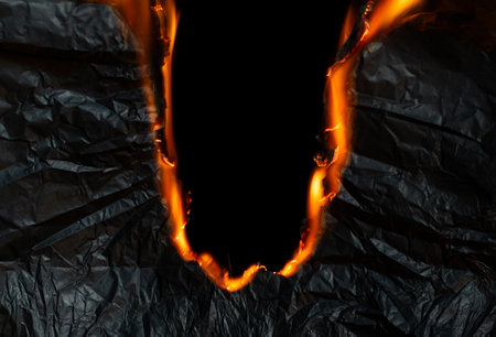 burning paper, glowing edge of paper on a black backgroundの写真素材