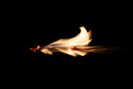 burning paper, glowing edge of paper on a black backgroundの写真素材
