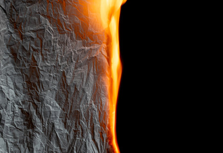 burning paper, glowing edge of paper on a black backgroundの写真素材