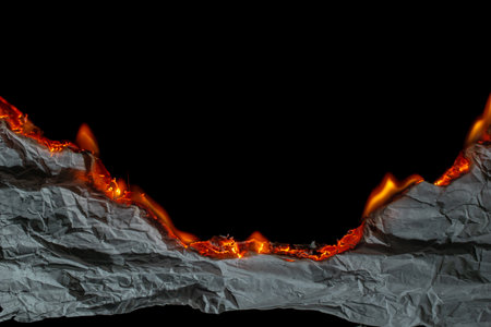 burning paper, glowing edge of paper on a black backgroundの写真素材