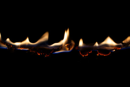burning paper, glowing edge of paper on a black backgroundの写真素材