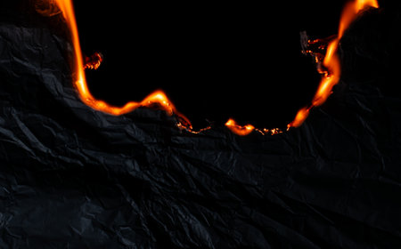burning paper, glowing edge of paper on a black backgroundの写真素材