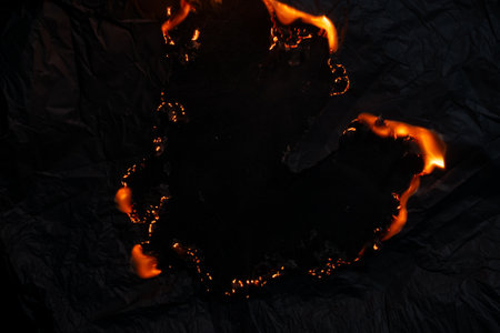 burning paper, glowing edge of paper on a black backgroundの写真素材