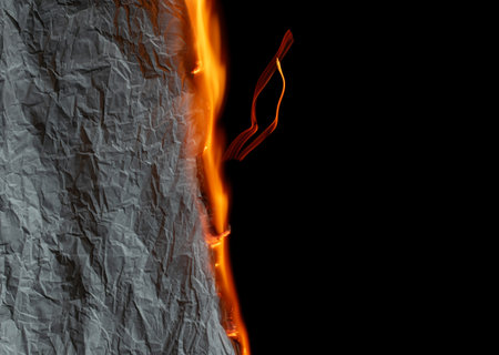 burning paper, glowing edge of paper on a black backgroundの写真素材