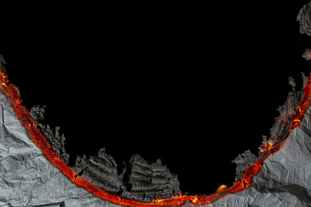 burning paper, glowing edge of paper on a black backgroundの写真素材