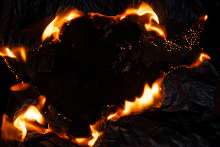 burning paper, glowing edge of paper on a black backgroundの写真素材