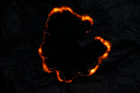 burning paper, glowing edge of paper on a black backgroundの写真素材