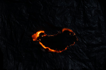 burning paper, glowing edge of paper on a black background
