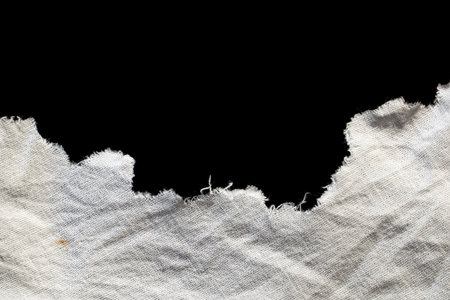 torn old white rag with holes on a black backgroundの写真素材