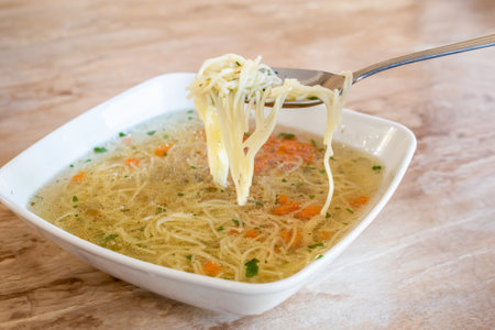 broth with noodles, decorated with parsley and carrotsの写真素材