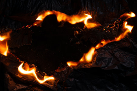 burning paper, glowing edge of paper on a black backgroundの写真素材