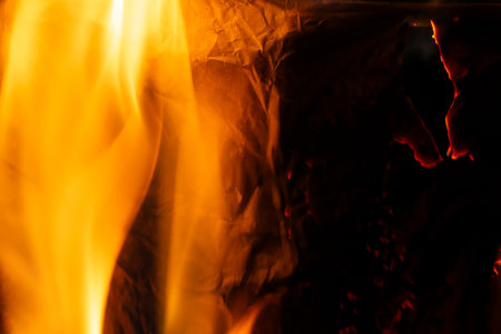 burning paper, glowing edge of paper on a black backgroundの写真素材