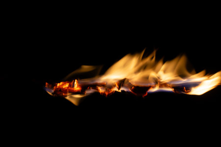 burning paper, glowing edge of paper on a black background