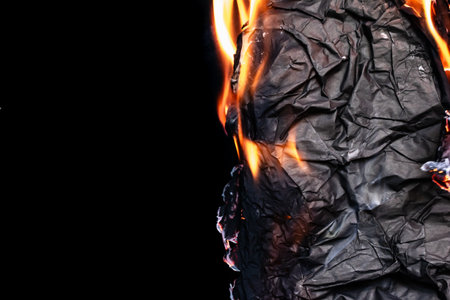 burning back paper, glowing edge of paper on a black backgroundの写真素材