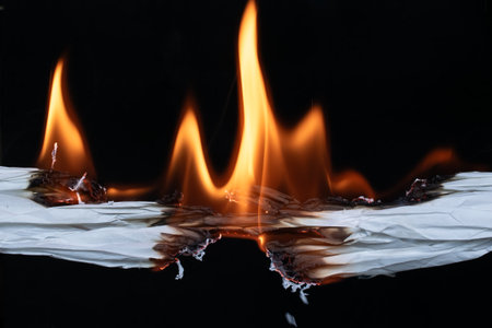 burning white paper, glowing edge of paper on a black backgroundの写真素材