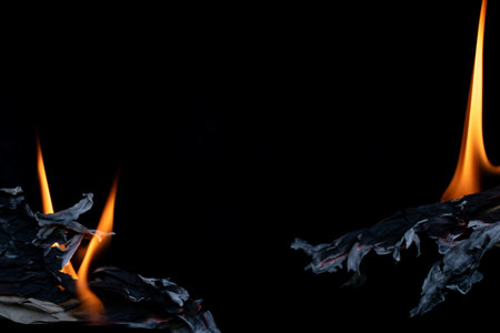 burning gray paper, glowing edge of paper on a black background