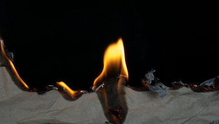 burning paper, glowing edge of paper on a black background