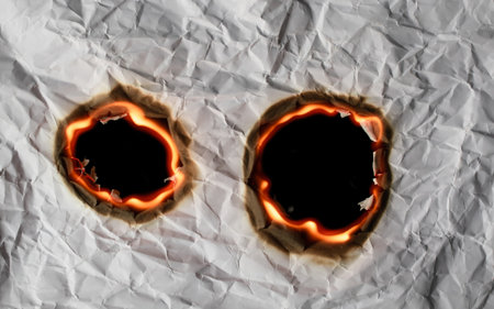 burning paper, glowing edge of paper on a black backgroundの写真素材