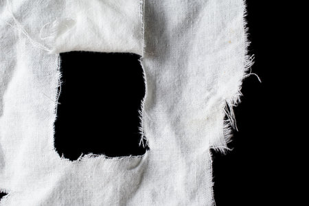 torn old white rag with holes on a black background
