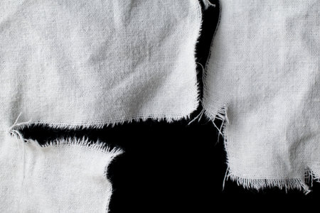 torn old white rag with holes on a black backgroundの写真素材