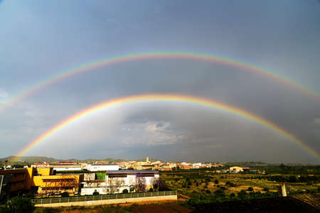 Double rainbow in villageの写真素材