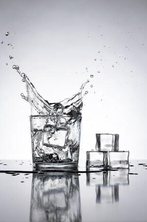 Ice cubes splashing into glassの写真素材