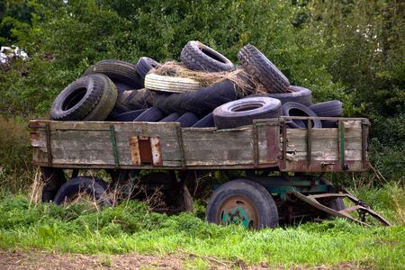 Old wooden wagon fulled with old tyresの写真素材