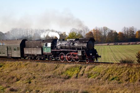 Old retro steam train passing through polish countryside