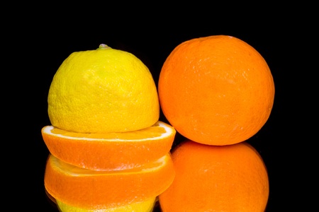 Lemon and orange isolated on black backgroundの写真素材