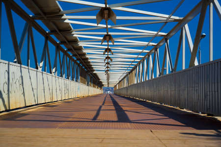 Steel and wooden bridge for pedestrians crossing over the railway tracksの写真素材