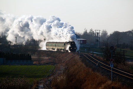 Vintage steam train passing through countryside, wintertimeの写真素材