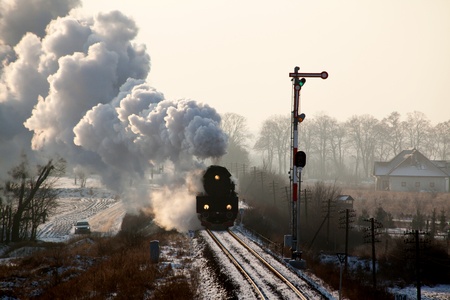 Vintage steam train starting from the station, wintertimeの写真素材