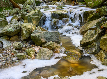 Beautiful frozen waterfall in the winter. Frozen water an ice everywhere. Amazing ice formations. Rocks surrounding the waterの写真素材