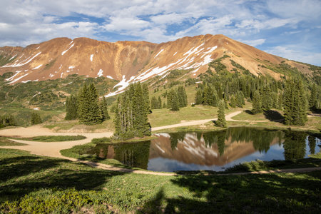 Beautiful mountain view with a clear, blue lake. Beautiful blue sky with clouds. Summer photo, but glaciers still have some snow left.の写真素材