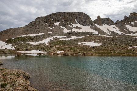 Beautiful mountain view with a clear, blue lake. Beautiful blue sky with clouds. Summer photo, but glaciers still have some snow left.の写真素材