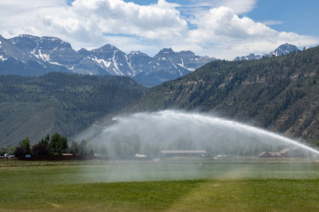 Watering the field in the valley between the mountains in Cclorado.の写真素材