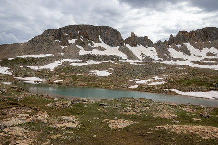Beautiful mountain view with a clear, blue lake. Beautiful blue sky with clouds. Summer photo, but glaciers still have some snow left.の写真素材