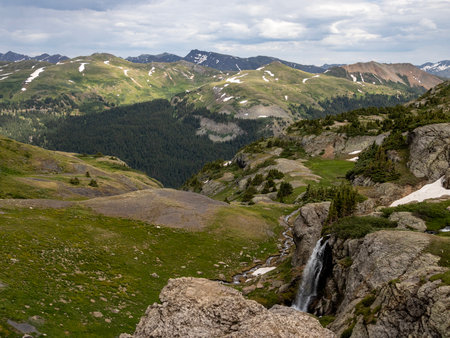 Beautiful scenery with waterfall and mountains in the background. Some snow on the glaciers still there in the Summerの写真素材