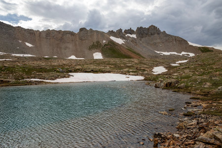 Beautiful mountain view with a clear, blue lake. Beautiful blue sky with clouds. Summer photo, but glaciers still have some snow left.の写真素材