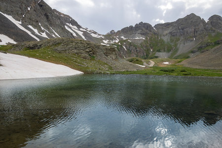 Beautiful mountain view with a clear, blue lake. Beautiful blue sky with clouds. Summer photo, but glaciers still have some snow left.の写真素材
