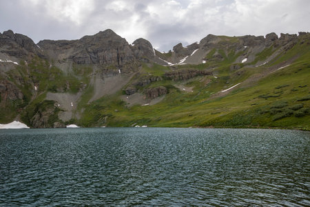 Beautiful mountain view with a clear, blue lake. Beautiful blue sky with clouds. Summer photo, but glaciers still have some snow left.の写真素材