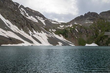 Beautiful mountain view with a clear, blue lake. Beautiful blue sky with clouds. Summer photo, but glaciers still have some snow left.の写真素材