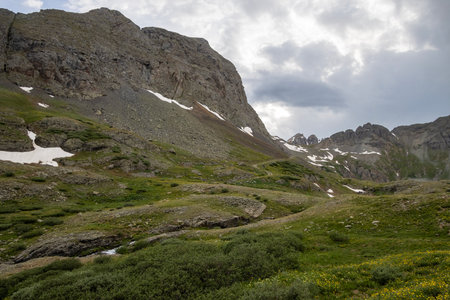 Beautiful mountain view. Summer picture with snow still sticking around on the glaciers. Small creek in the foregroundの写真素材