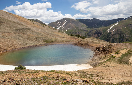 Beautiful mountain view with a clear, blue lake. Beautiful blue sky with clouds. Summer photo, but glaciers still have some snow left.の写真素材