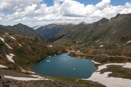 Beautiful mountain view with a clear, blue lake. Beautiful blue sky with clouds. Summer photo, but glaciers still have some snow left.の写真素材