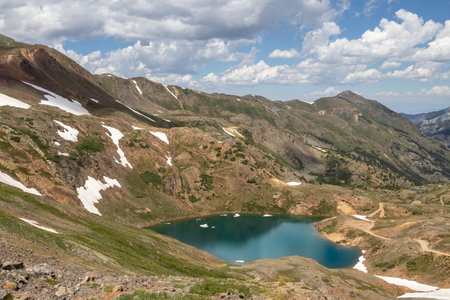Beautiful mountain view with a clear, blue lake. Beautiful blue sky with clouds. Summer photo, but glaciers still have some snow left.の写真素材
